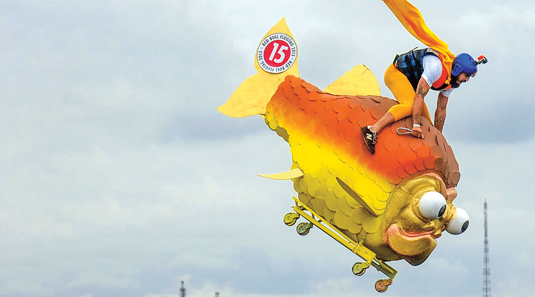 Image of person riding giant fish vehicle through the air
