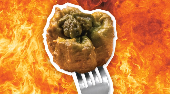 Image of the Pepper X on a fork against backdrop of flames