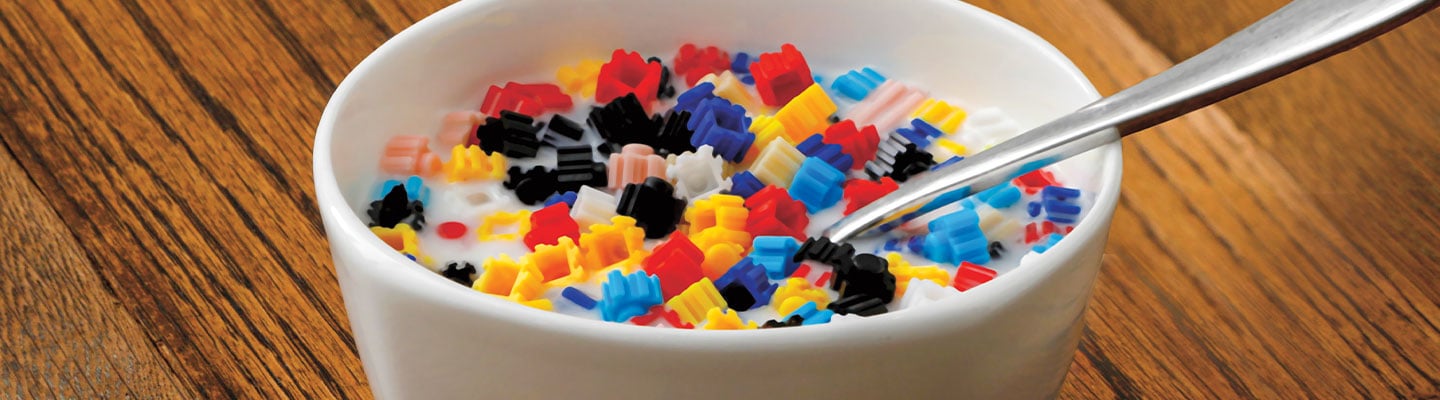 A cereal bowl filled with colorful plastic pieces in milk